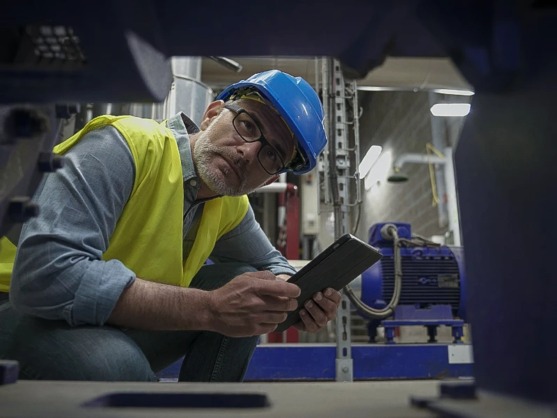 Man in work clothes looks into a machine